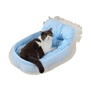 Chat installé dans le panier Princesse à motif vichy bleu avec bordure volantée sur fond blanc